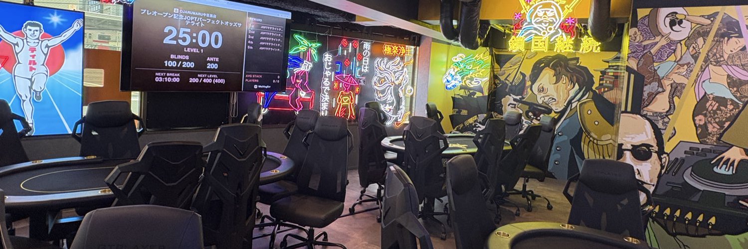 中目黒でポーカーが楽しめるOJARUMARU中目黒店の店内。ポーカーテーブルとネオンサインが並ぶ